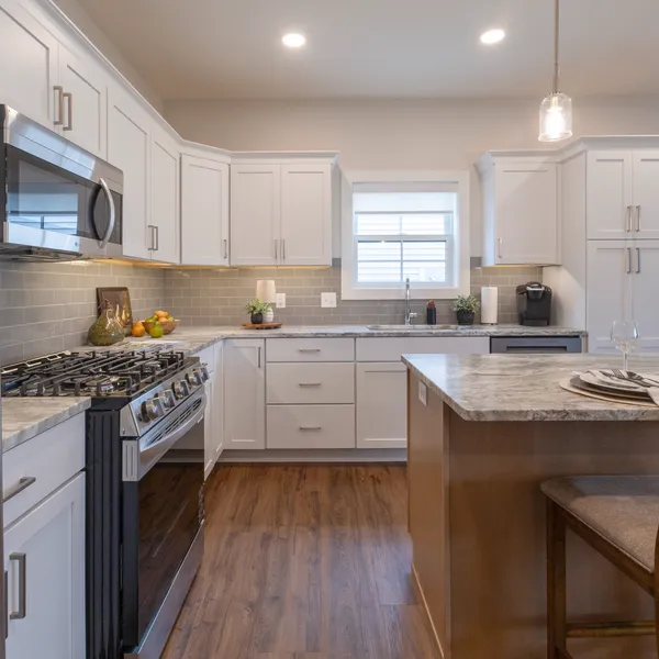 Full kitchen with white shaker cabinets and granite countertops in a Rabbit Ridge retirement home in Syracuse, Indiana.