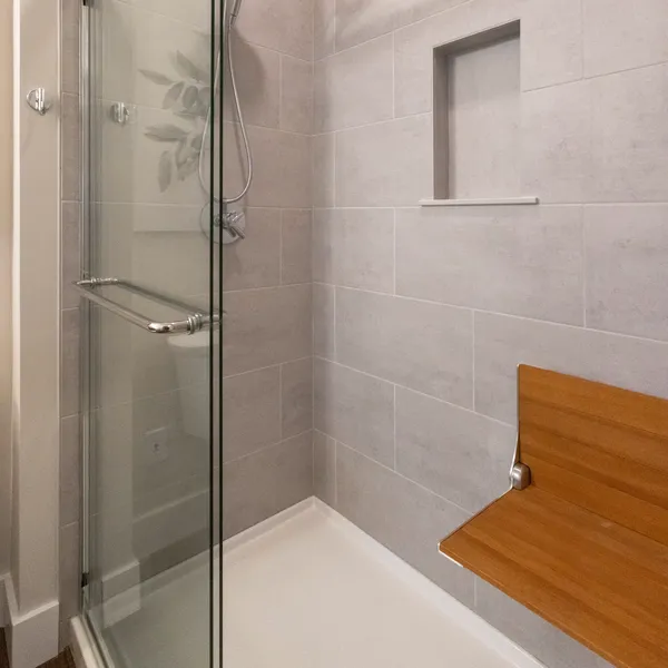 Age-in-place walk-in shower with fold-down seat and grab bar at Rabbit Ridge Senior Living in Syracuse, Indiana.